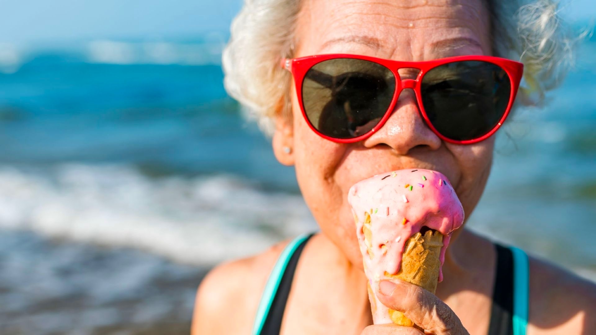 Older lady at beach eating ice cream